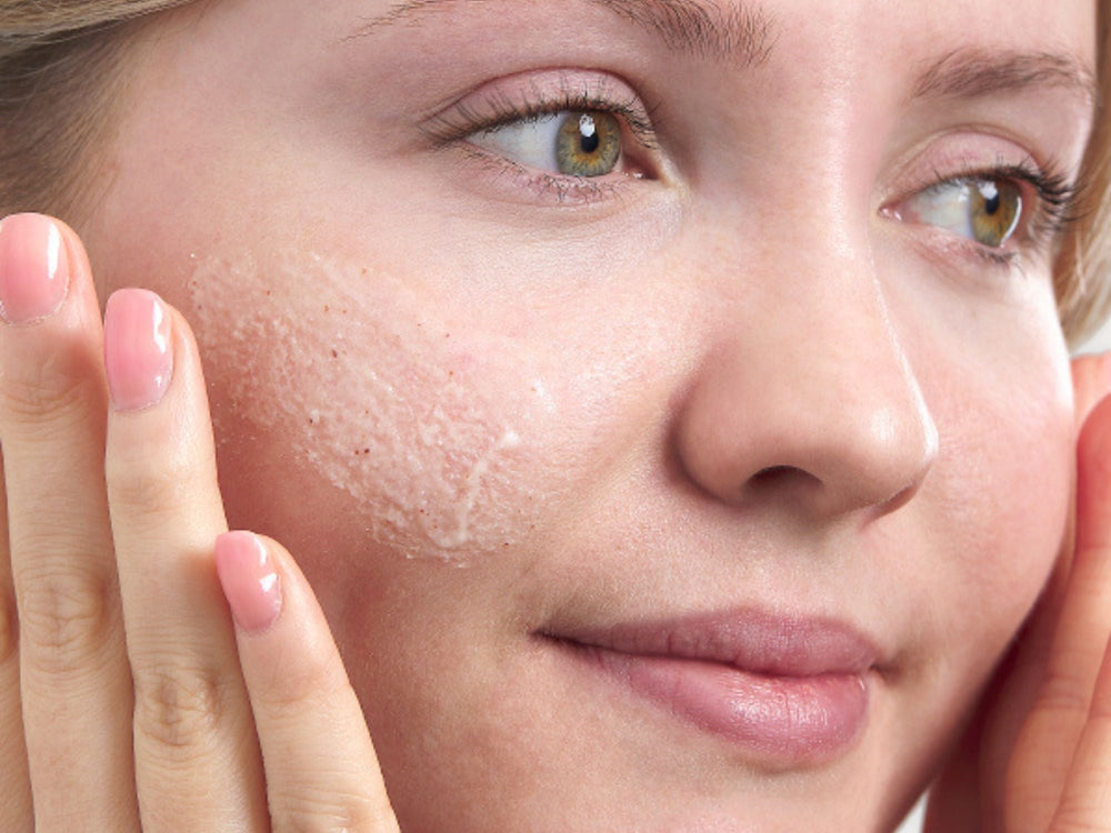 Image of women applying a face scrub to her cheeks