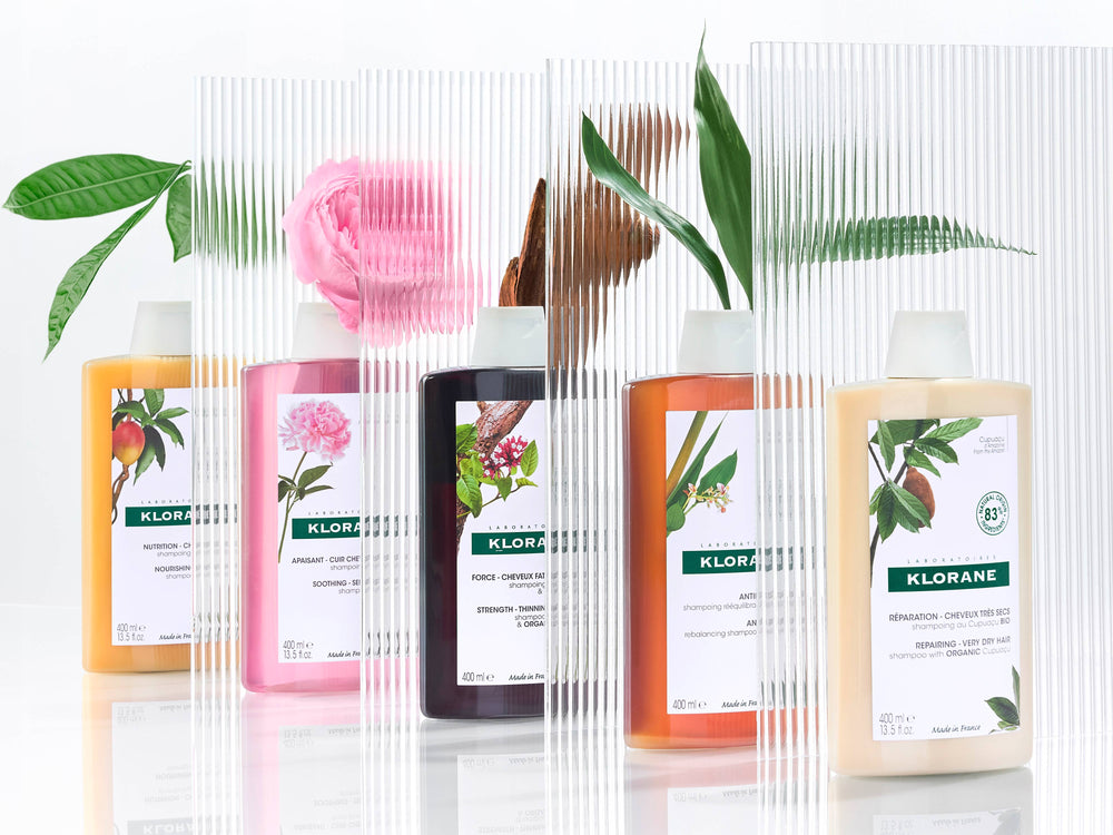 Klorane Shampoos in a row between frosted glass